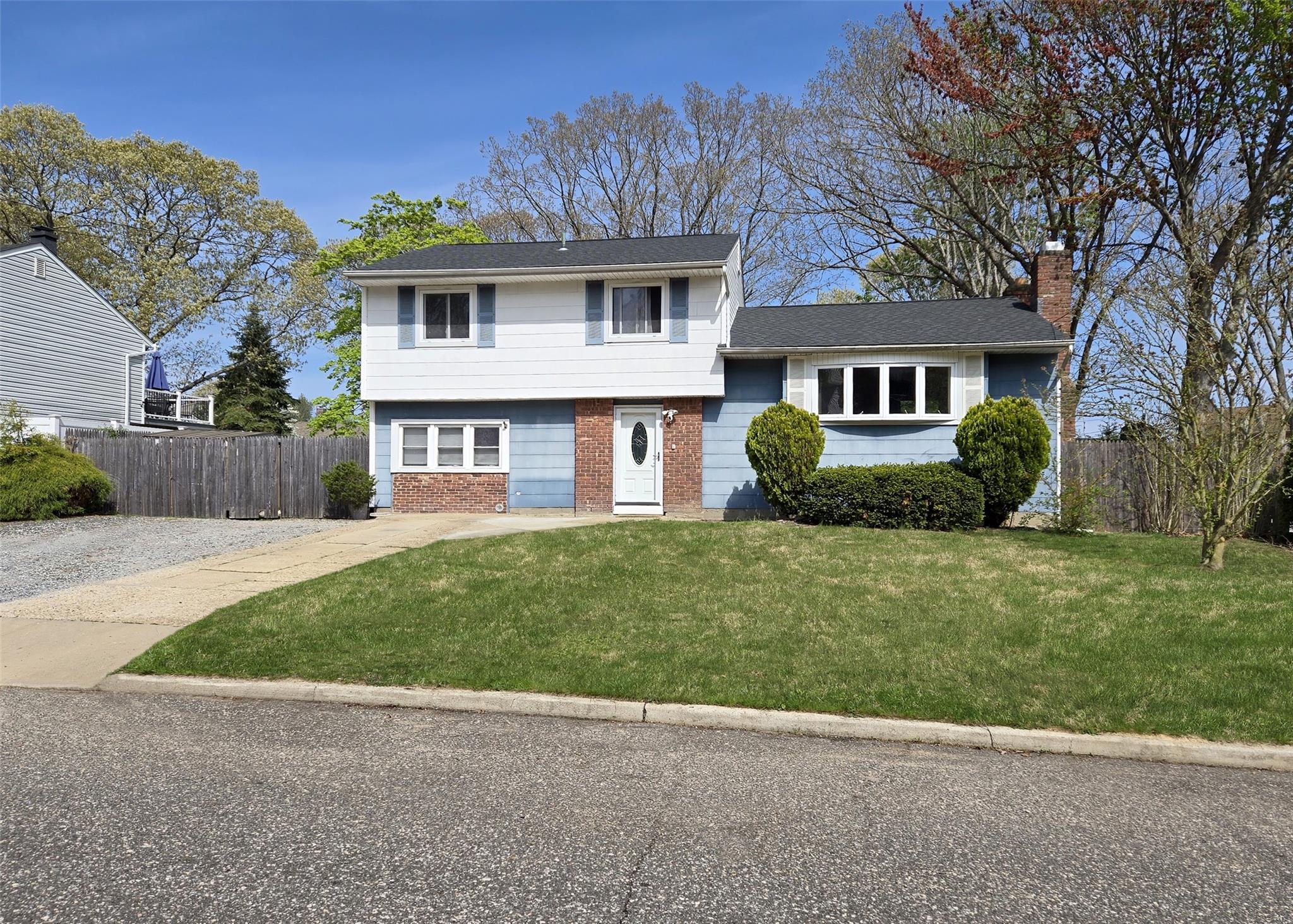 127 Ruland Road North Selden, NY 11784 - Photo 1 of 1 Split level home featuring fence, a chimney, brick siding, and a front yard