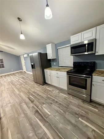a kitchen with stainless steel appliances granite countertop a stove and a microwave