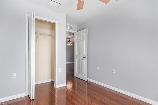 an empty room with wooden floor and closet