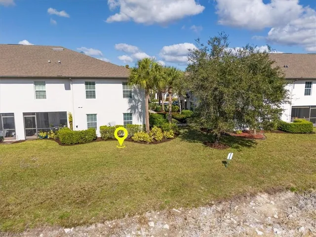 a view of a house with backyard and sitting area