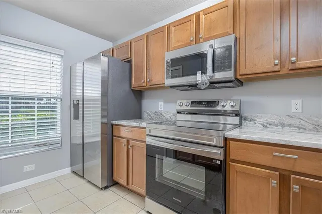a kitchen with stainless steel appliances granite countertop white cabinets and a stove top oven