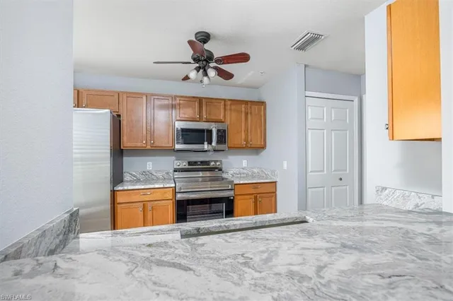 a kitchen with stainless steel appliances a stove a sink and a microwave