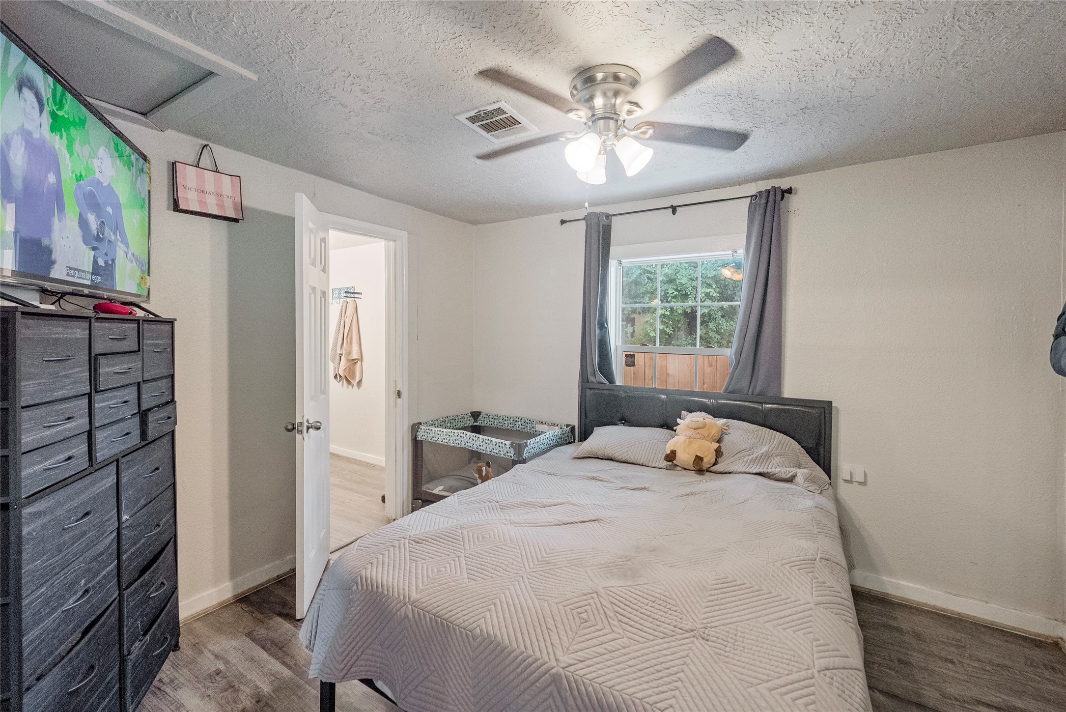 7938 Kerr Street, Unit 6 Houston, TX 77029 - Photo 9 of 18 a bedroom with a large bed and a chandelier