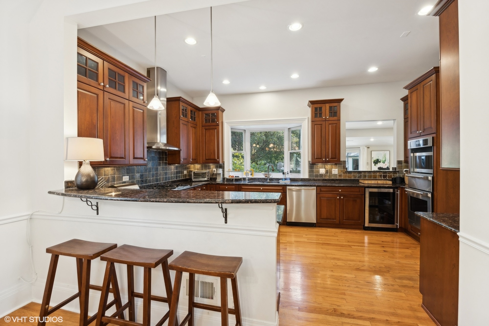 129 Barrypoint Road Riverside, IL 60546 - Photo 12 of 39 a kitchen with stainless steel appliances granite countertop a stove top oven a sink dishwasher a refrigerator and white cabinets with wooden floor
