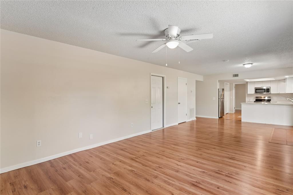 1907 Rambling Lane Brandon, FL 33510 - Photo 13 of 24 a view of an empty room with wooden floor and a ceiling fan