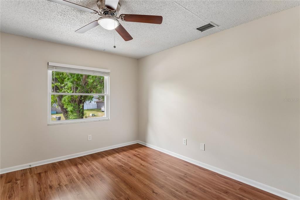 1907 Rambling Lane Brandon, FL 33510 - Photo 22 of 24 a view of an empty room with wooden floor and a window