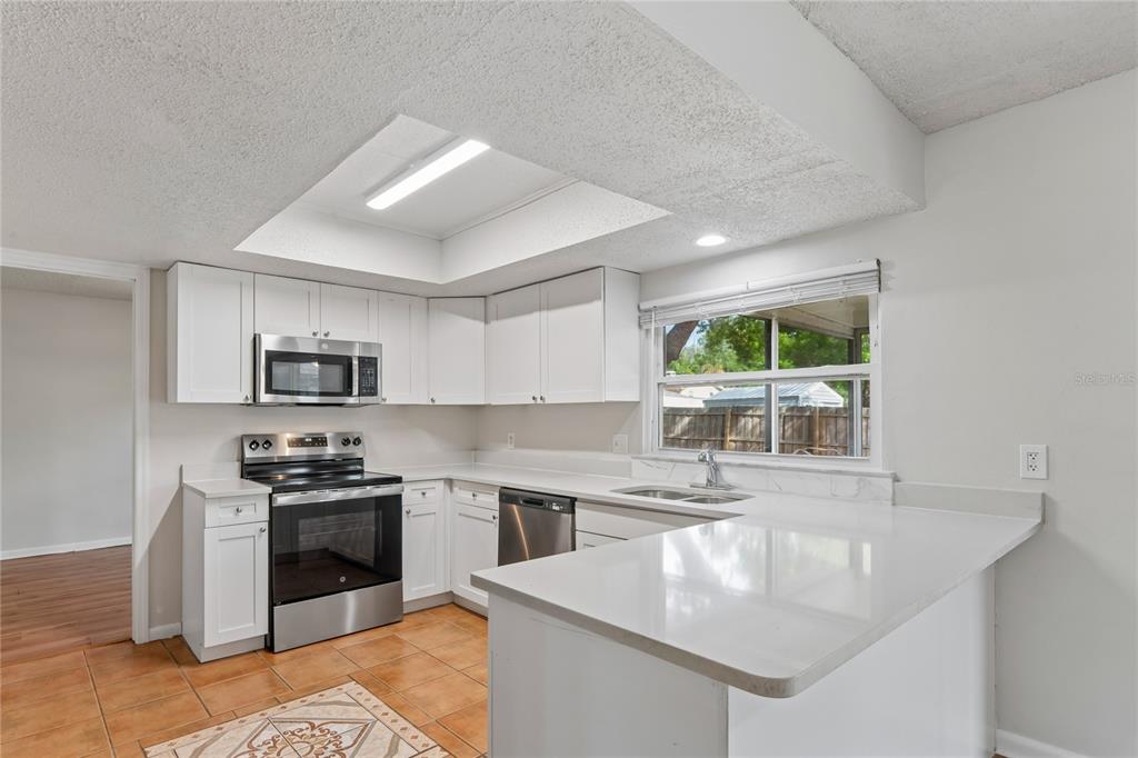 1907 Rambling Lane Brandon, FL 33510 - Photo 6 of 24 a kitchen with stainless steel appliances granite countertop a sink stove and refrigerator