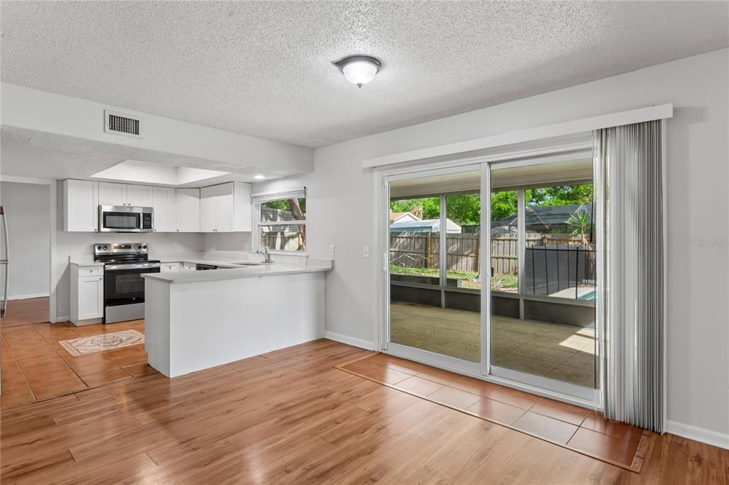 1907 Rambling Lane Brandon, FL 33510 - Photo 9 of 24 a kitchen with white cabinets and wooden floor