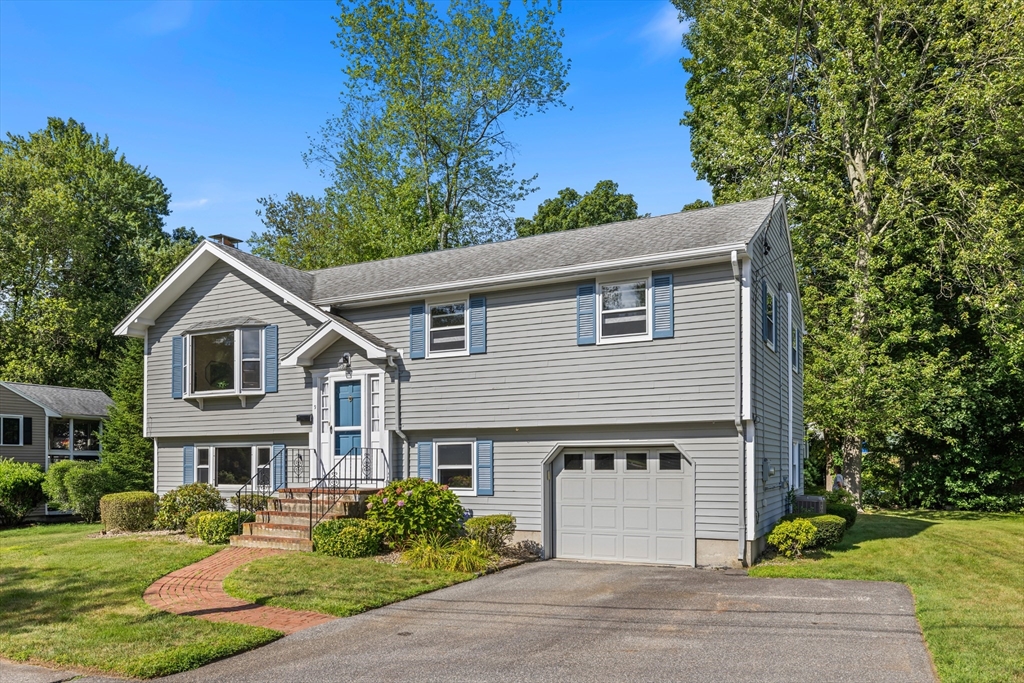 9 Hemlock Road Reading, MA 01867 - Photo 2 of 42 a front view of a house with a yard and garage