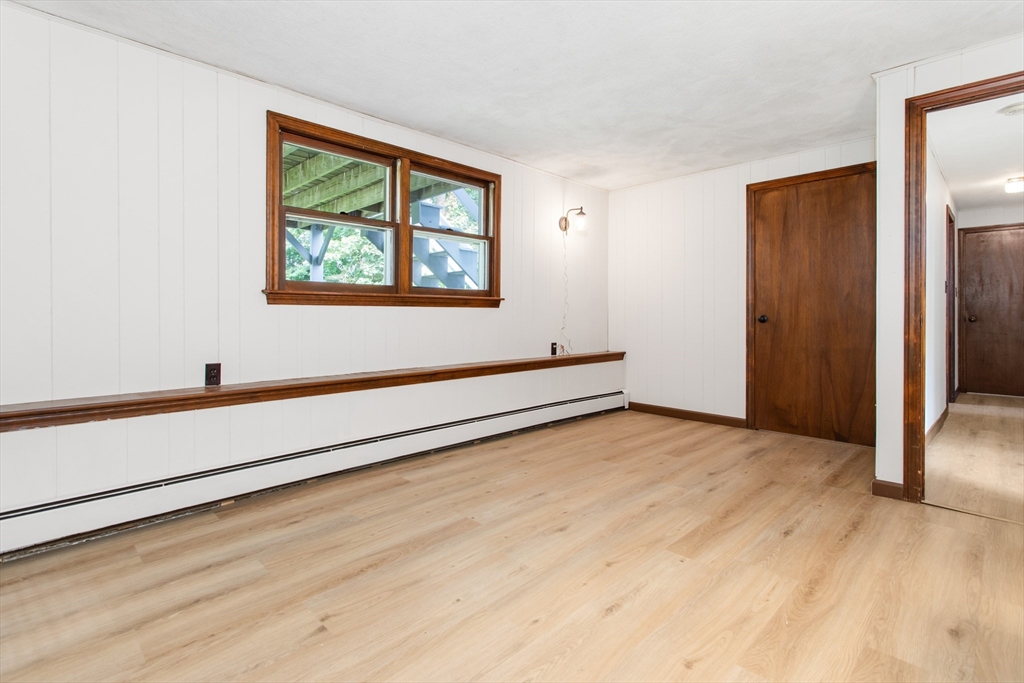 9 Hemlock Road Reading, MA 01867 - Photo 31 of 42 a view of an empty room with wooden floor and a window
