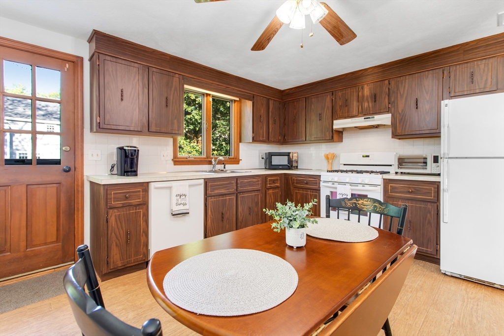 9 Hemlock Road Reading, MA 01867 - Photo 9 of 42 a kitchen with a table chairs sink and cabinets