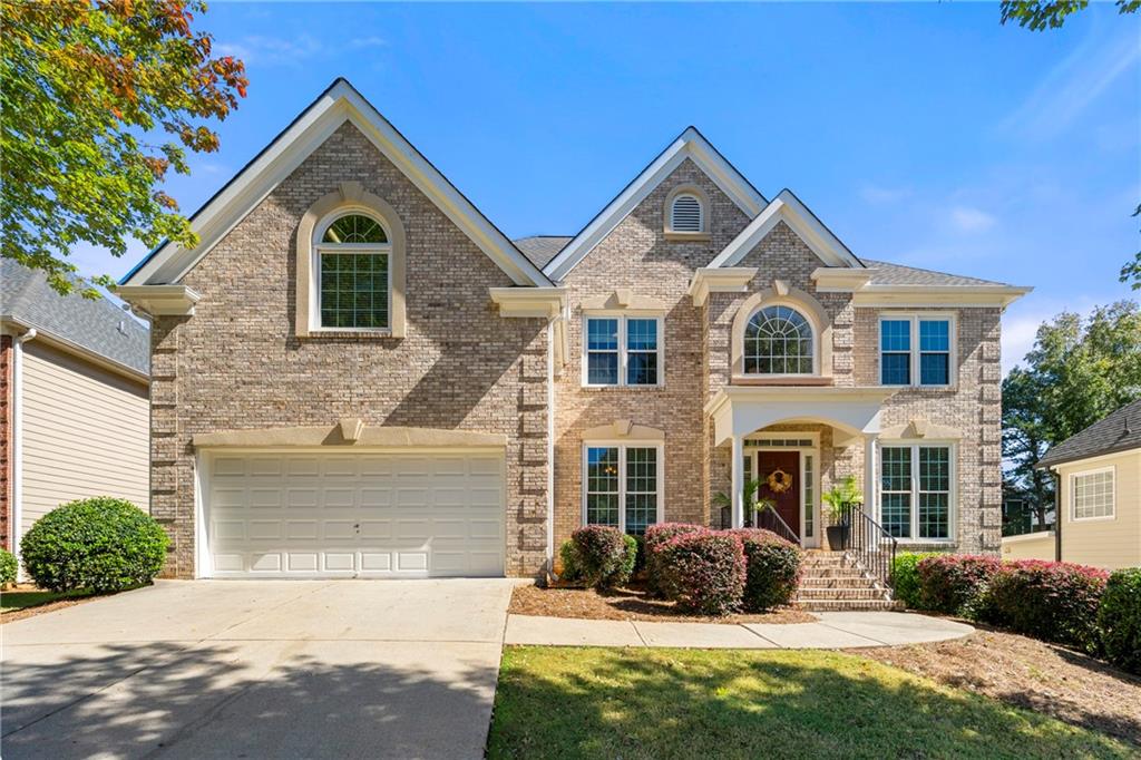 12579 Huntington Trace Alpharetta, GA 30005 - Photo 1 of 64 a front view of a house with a yard