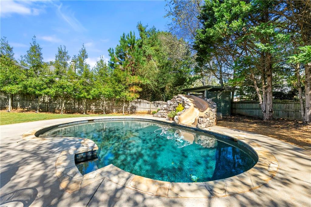 12579 Huntington Trace Alpharetta, GA 30005 - Photo 2 of 64 a view of a swimming pool with a patio