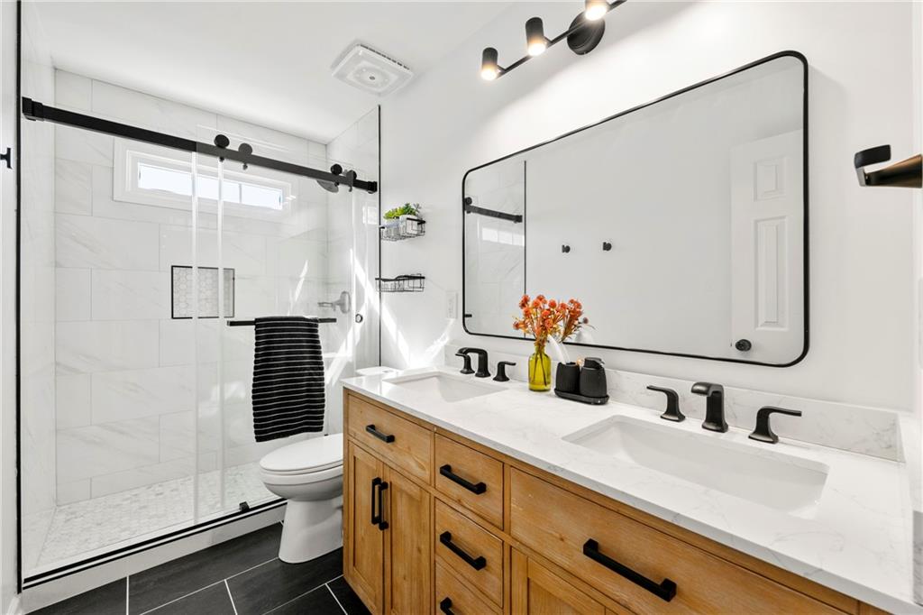 12579 Huntington Trace Alpharetta, GA 30005 - Photo 30 of 64 a bathroom with a double vanity sink toilet and shower