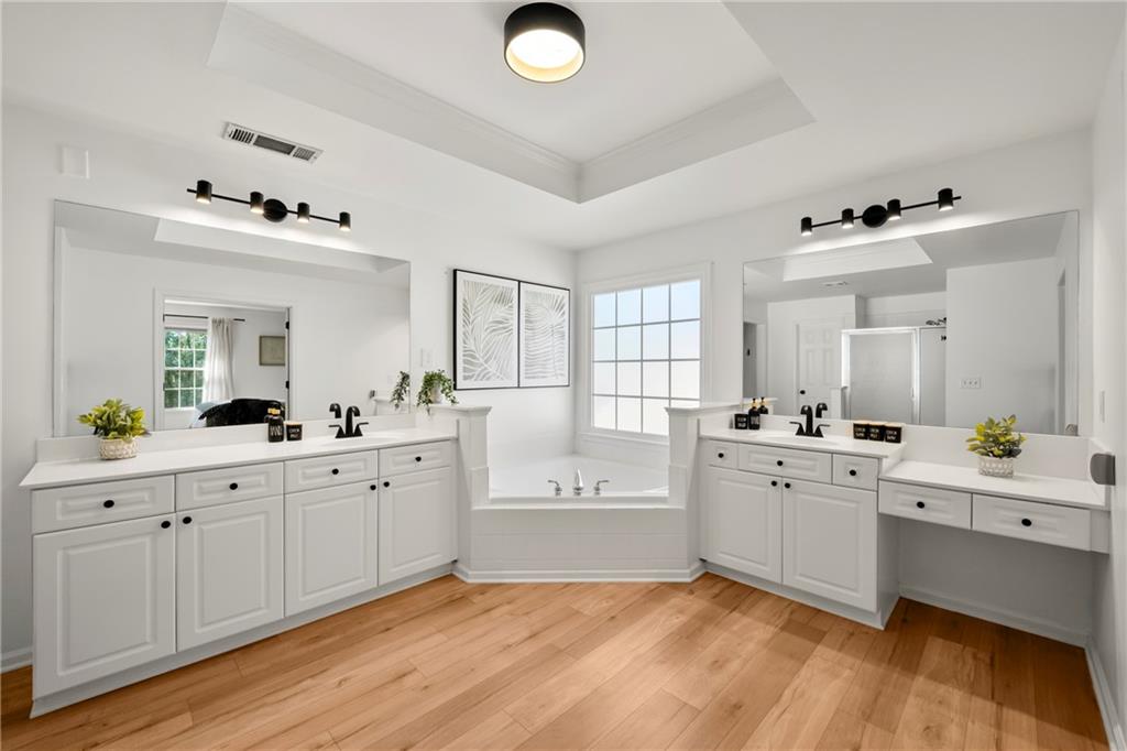 12579 Huntington Trace Alpharetta, GA 30005 - Photo 35 of 64 a large white kitchen with a sink cabinets and wooden floor