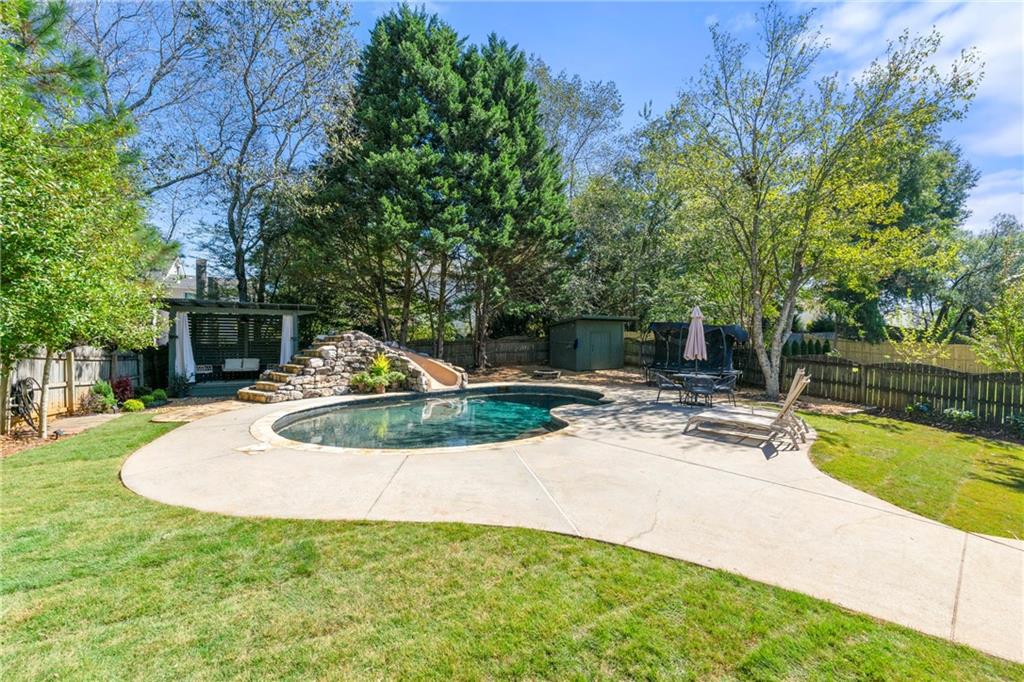 12579 Huntington Trace Alpharetta, GA 30005 - Photo 53 of 64 a view of a swimming pool with a yard