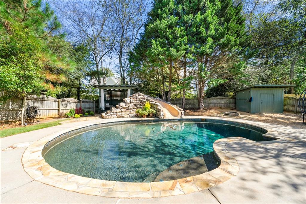 12579 Huntington Trace Alpharetta, GA 30005 - Photo 54 of 64 a view of a swimming pool with a patio