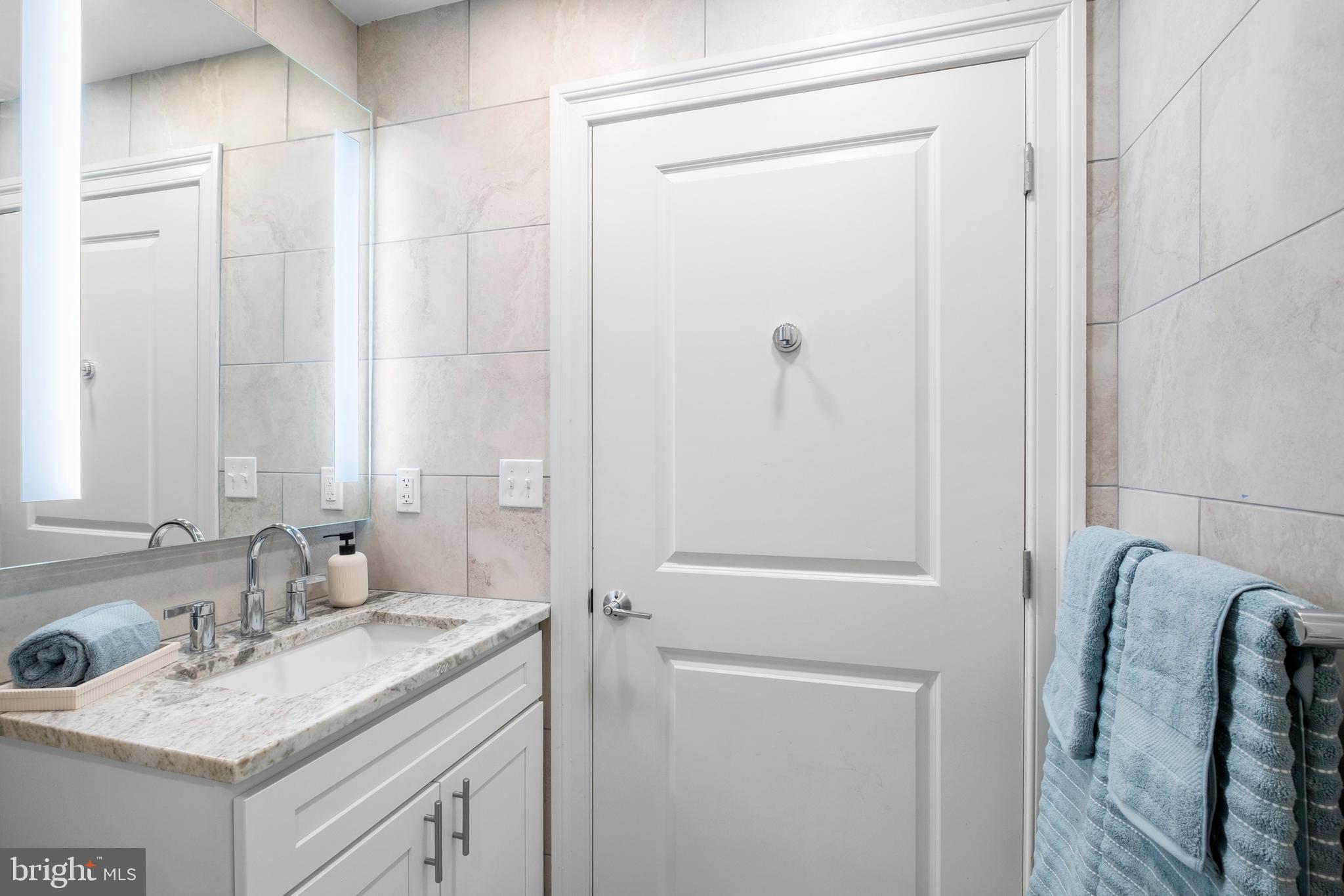 1420-22 Chestnut Street, Unit 301 Philadelphia, PA 19102 - Photo 15 of 29 a bathroom with a granite countertop sink shower and a mirror