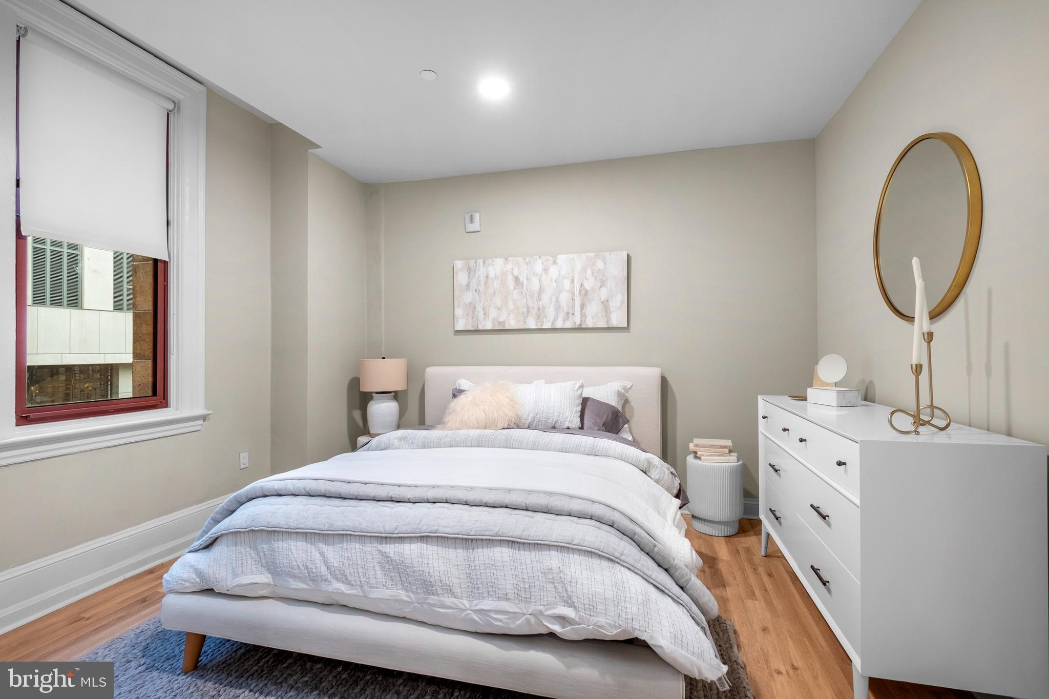 1420-22 Chestnut Street, Unit 301 Philadelphia, PA 19102 - Photo 17 of 29 a bedroom with a bed and a chandelier