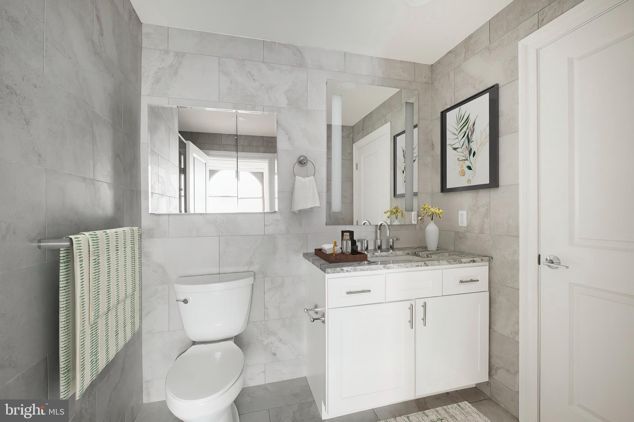 1420-22 Chestnut Street, Unit 301 Philadelphia, PA 19102 - Photo 25 of 29 a bathroom with a granite countertop toilet sink and mirror
