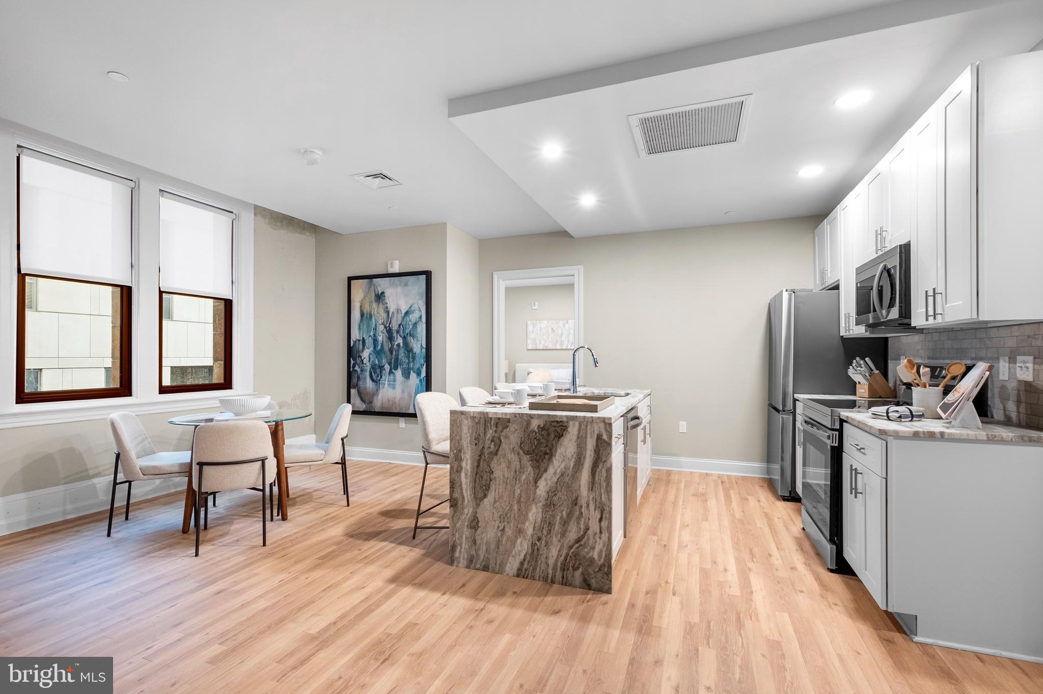 1420-22 Chestnut Street, Unit 301 Philadelphia, PA 19102 - Photo 6 of 29 a living room with stainless steel appliances furniture wooden floor and a kitchen view