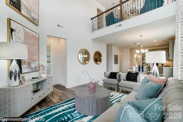 a living room with furniture kitchen view and a large window