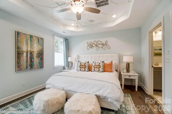 a bedroom with a large bed and a chandelier