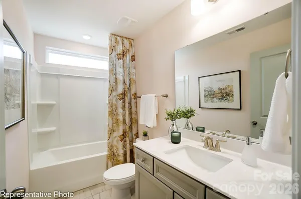 a bathroom with a sink a toilet and a large mirror