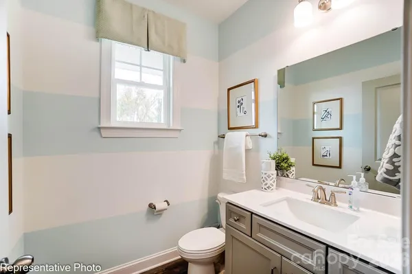 a bathroom with a granite countertop sink a toilet and a mirror