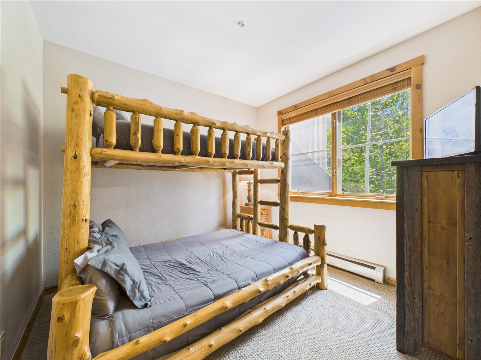 27 Lake Ridge Circle, Unit 1842 Keystone, CO 80435 - Photo 18 of 50 Main floor bedroom, sunny and comfortable with rustic log bunk bed and views of surrounding trees.