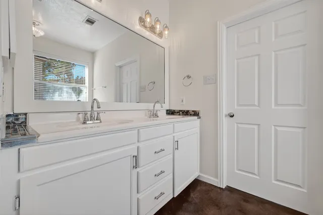 a bathroom with a double vanity sink a mirror and a bathtub