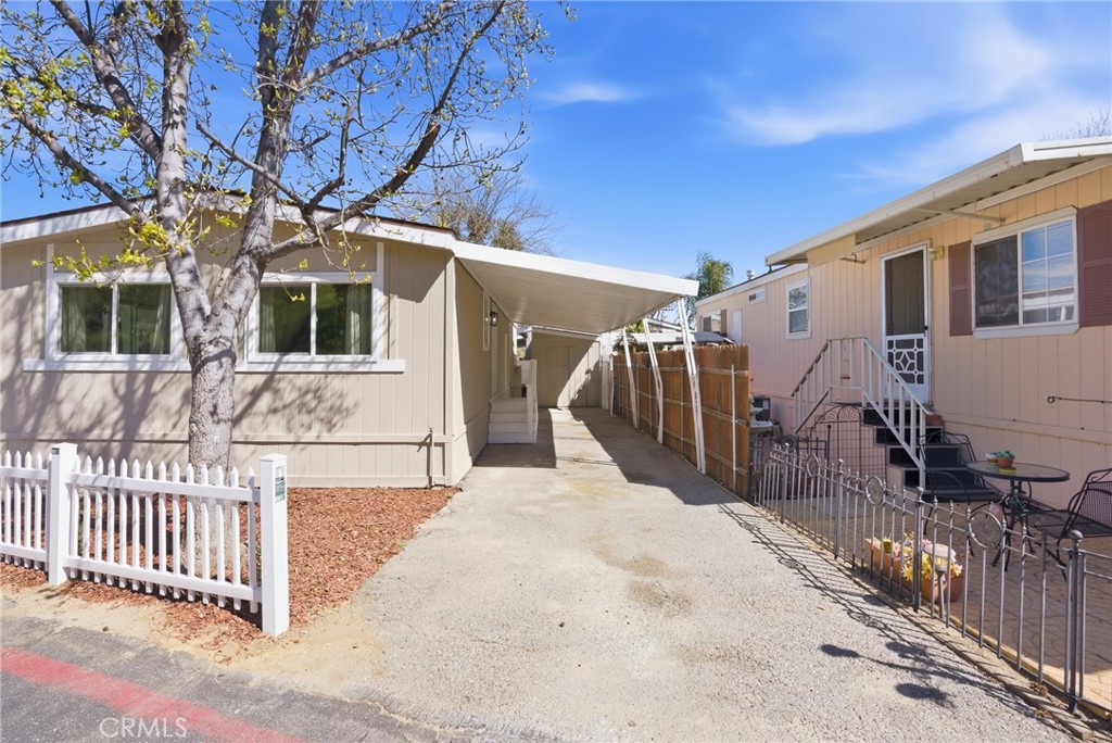 30000 Hasley Canyon Road, Unit 16 Castaic, CA 91384 - Photo 3 of 34 a view of a house with a small yard and large tree