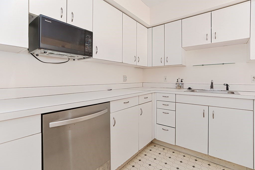 59 Brainerd Road, Unit 406 Boston, MA 02134 - Photo 17 of 19 a kitchen with white cabinets sink and white appliances