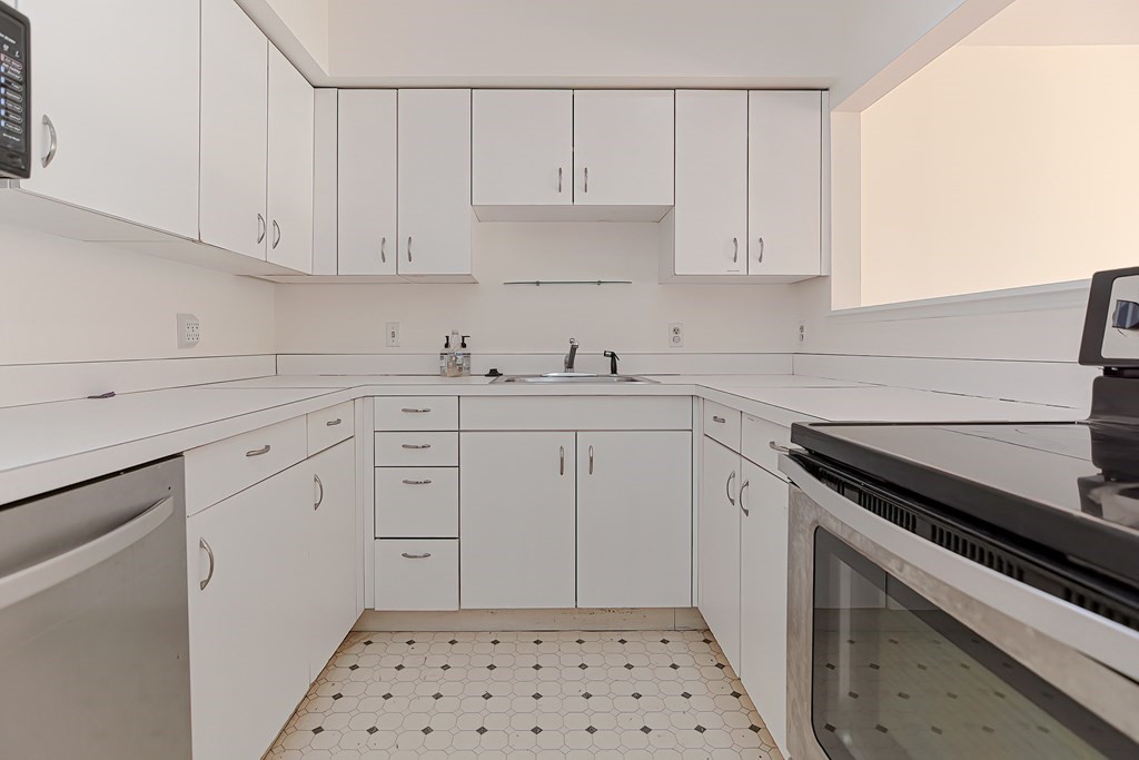 59 Brainerd Road, Unit 406 Boston, MA 02134 - Photo 18 of 19 a kitchen with white cabinets and appliances