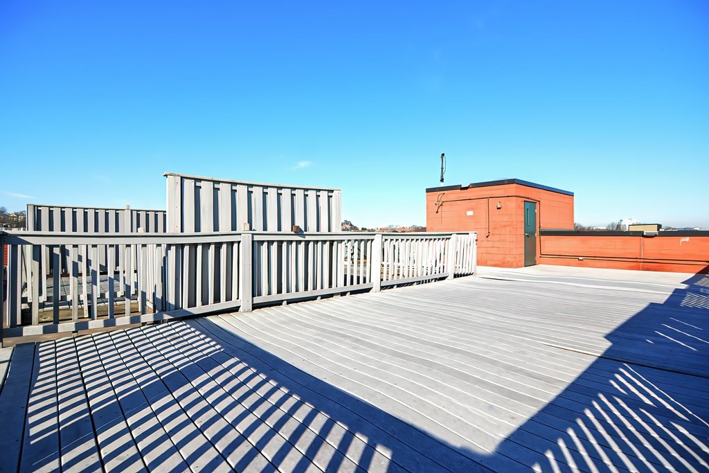 59 Brainerd Road, Unit 406 Boston, MA 02134 - Photo 7 of 19 a terrace view with wooden floor and fence