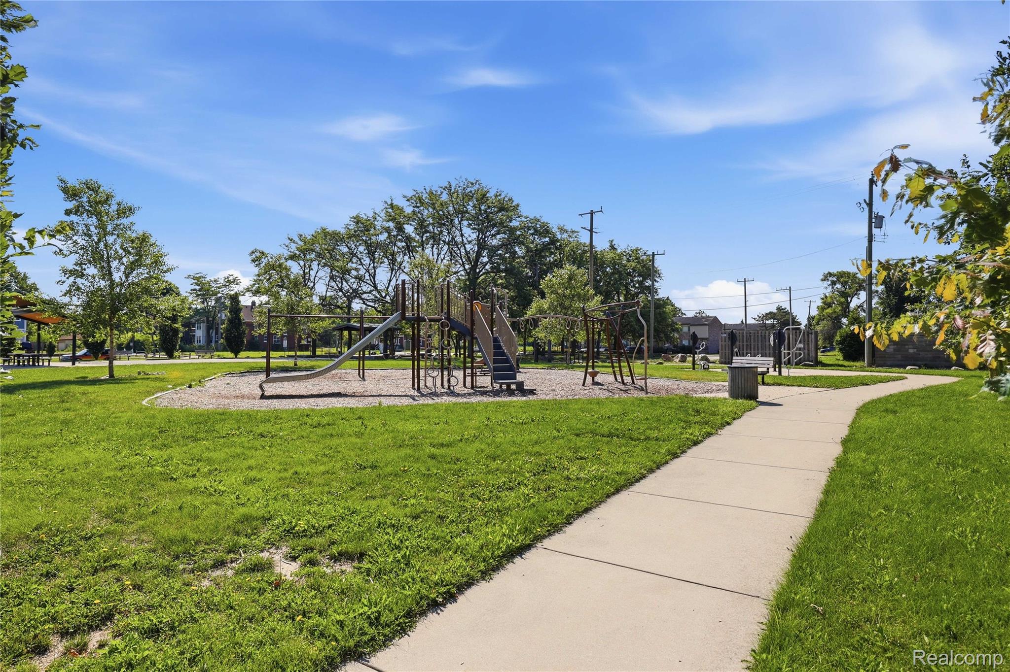 1945 Atkinson Street Detroit, MI 48206 - Photo 40 of 49 Expansive park space featuring a playground with slides and climbing structures, surrounded by lush green grass and mature trees