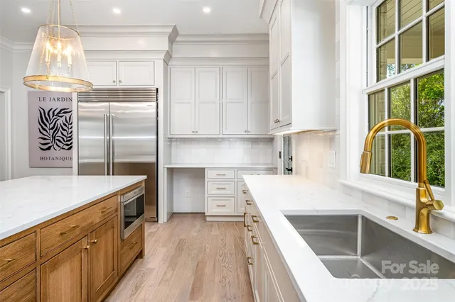 a kitchen with kitchen island granite countertop a sink cabinets and stainless steel appliances