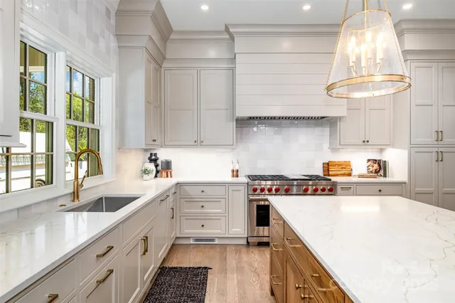 a kitchen with kitchen island granite countertop a sink a counter space appliances and cabinets