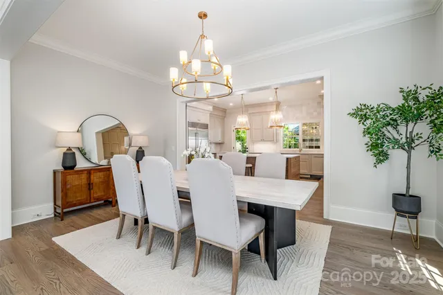 a view of a dining room with furniture a chandelier and wooden floor