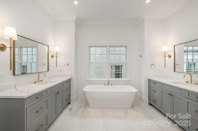 a bathroom with a double vanity sink large mirror a bathtub and window