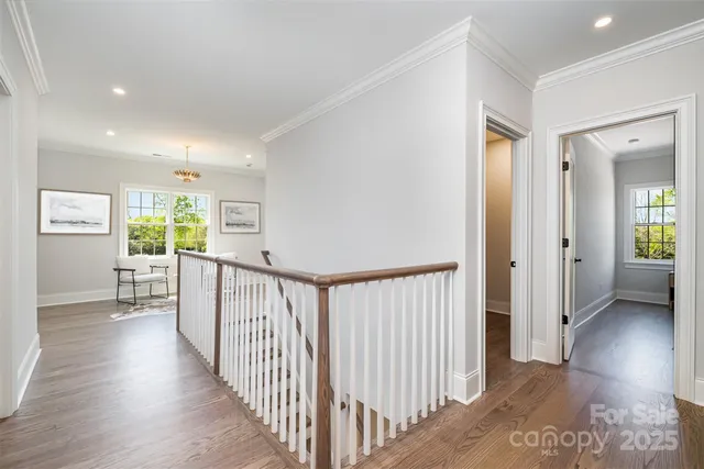 a view of a hallway with wooden floor and windows