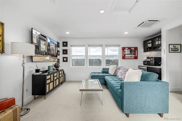 a living room with furniture a flat screen tv and a floor to ceiling window