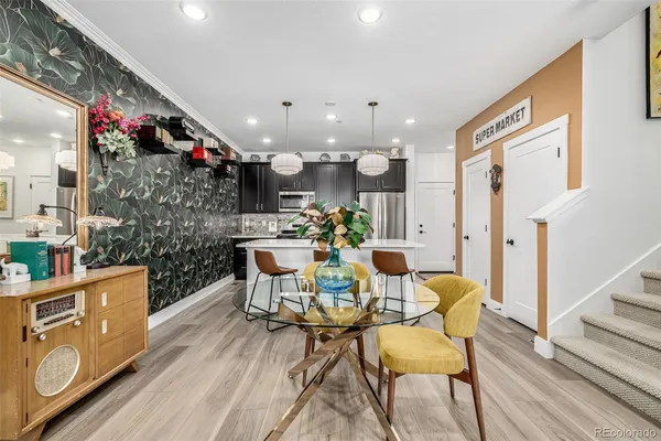 a kitchen with stainless steel appliances kitchen island granite countertop a refrigerator a stove a sink and a oven with wooden floor