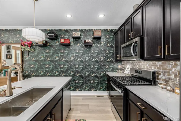 a kitchen with stainless steel appliances granite countertop a sink stove and refrigerator
