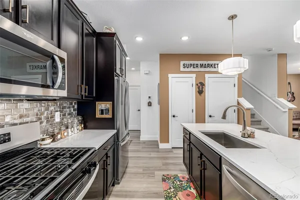 a kitchen with stainless steel appliances granite countertop a stove and a wooden floors