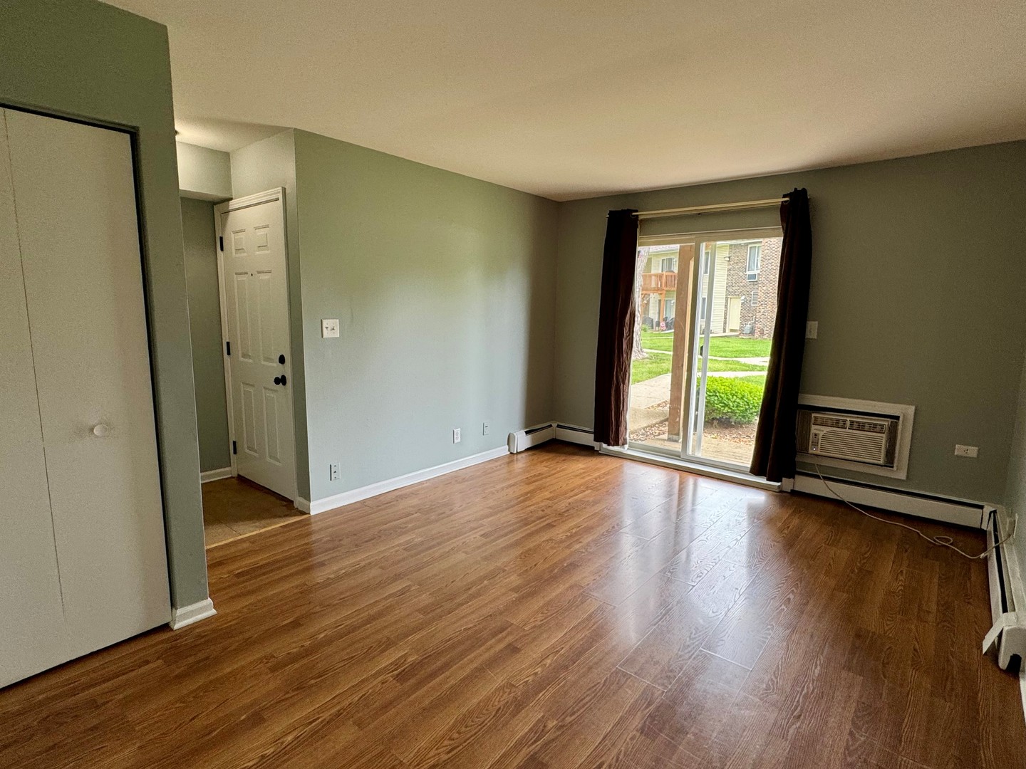 1900 Light Road, Unit 111 Oswego, IL 60543 - Photo 3 of 9 an empty room with wooden floor and windows