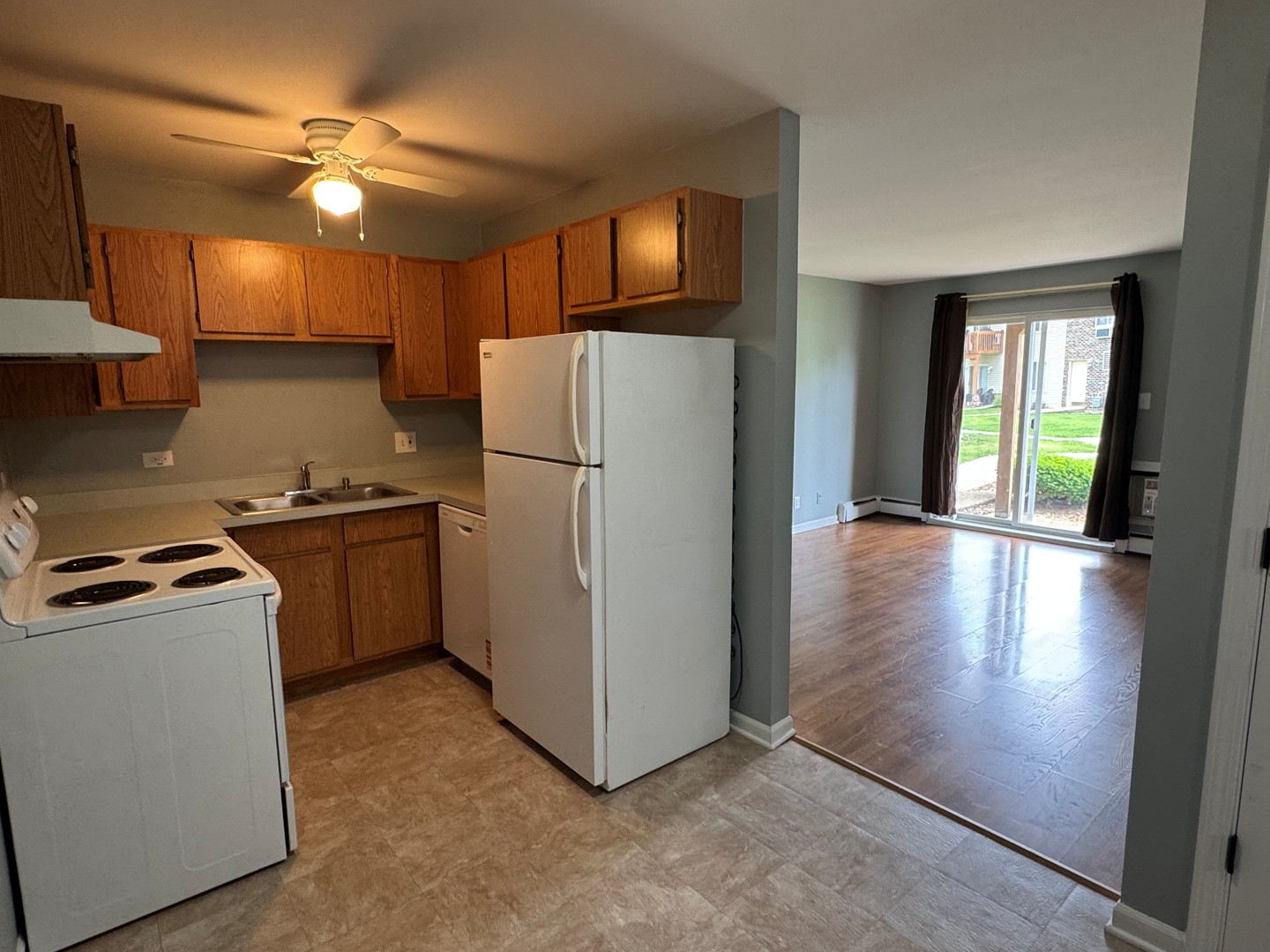 1900 Light Road, Unit 111 Oswego, IL 60543 - Photo 5 of 9 a kitchen with a refrigerator a stove top oven a sink and dishwasher