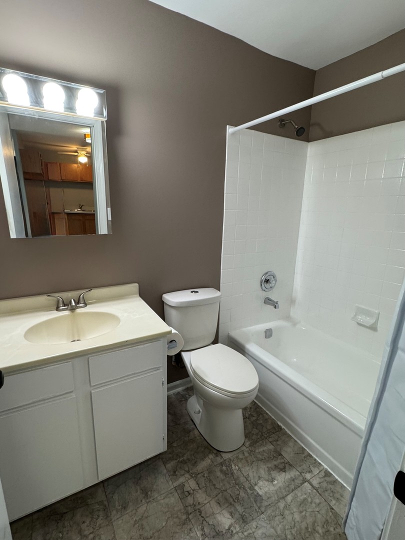 1900 Light Road, Unit 111 Oswego, IL 60543 - Photo 8 of 9 a bathroom with a sink toilet a mirror and shower