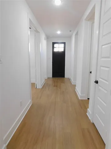 a view of a small space with wooden floor and a window