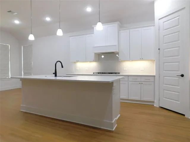 a kitchen with kitchen island a counter top space cabinets and stainless steel appliances